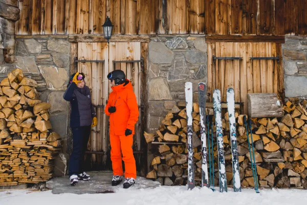 deux skieurs devant un chalet en hiver