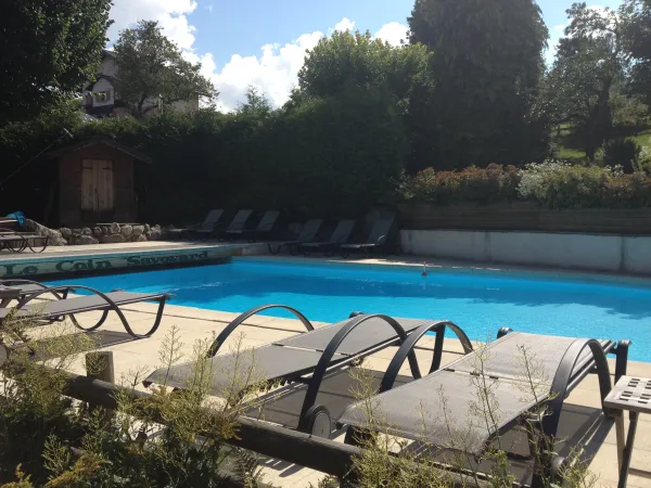 Transats au bord de la piscine du Piscine du u restaurant le Coin savoyard