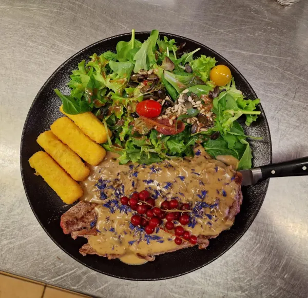Assiette de viande en sauce, salade, groseilles