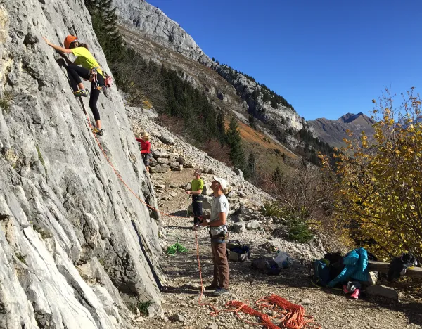 personnes en bas d'un mur d'escalade naturel