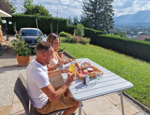 Voyageurs savourant leur petit-déjeuner bio devant panorama de 125 km de montagnes