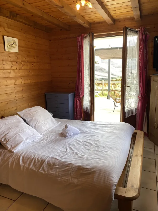 Chambre avec lit double, porte-fenêtre donnant accès à la terrasse