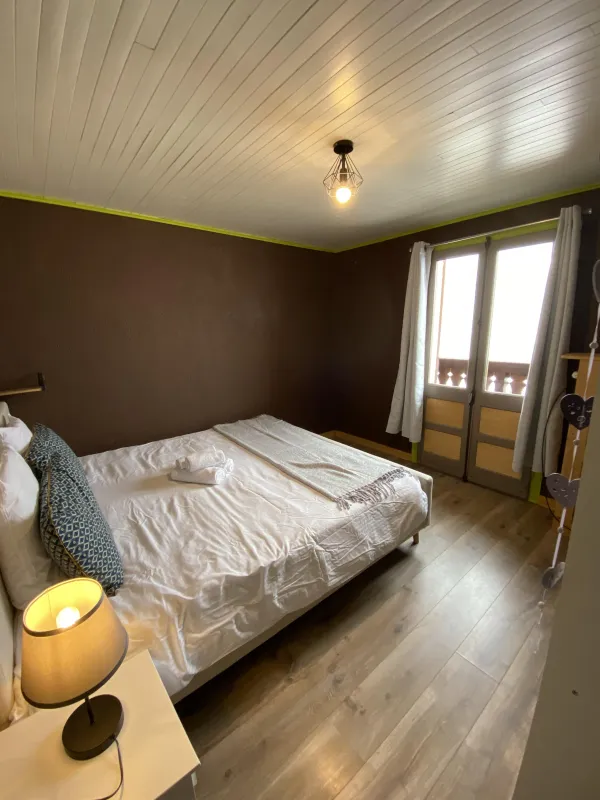 Chambre double avec grand lit, porte fenêtre donnant sur le balcon