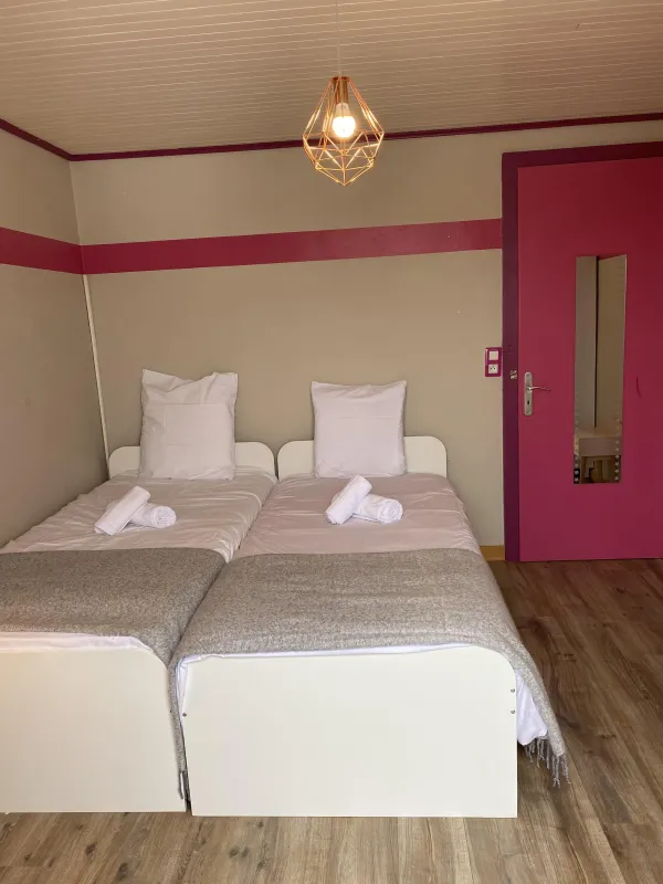 Chambre twin avec deux lits simple, porte rose