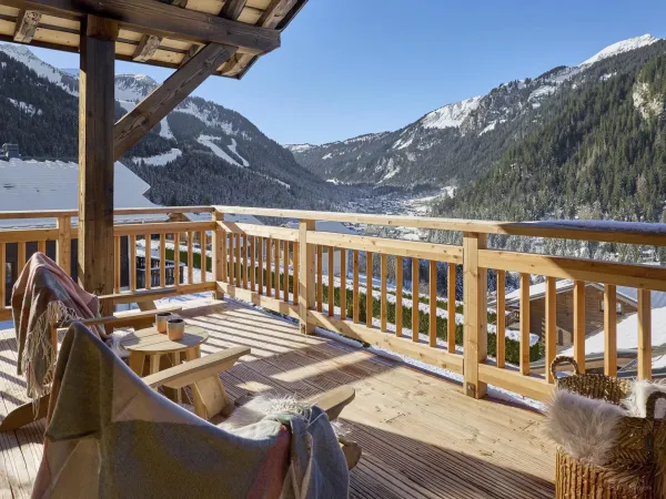 Terrasse couverte avec mobilier de jardin, vue sur les montagnes enneigées