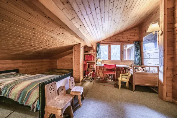 Chambre mansardée avec deux lits, bureau sous la fenêtre