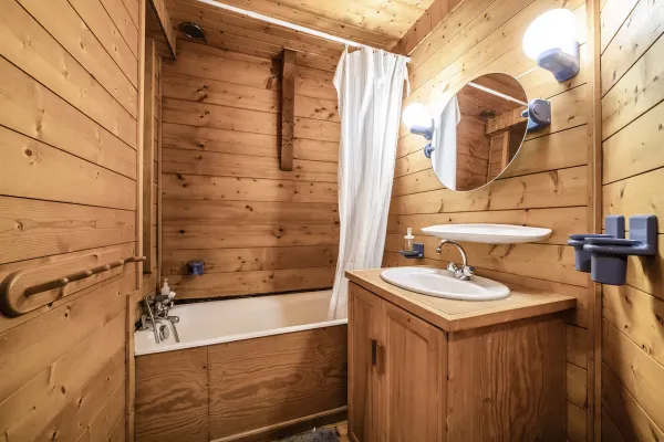 Salle de bains tout en bois avec baignoire, lavabo et son meuble, miroir