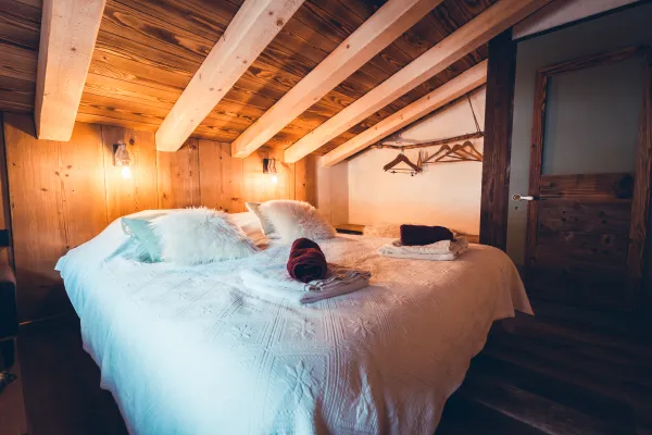 Chambre avec un grand lit, poutres apparentes