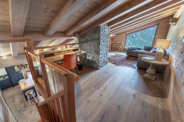 Espace détente avec coin bureau, canapé, fenêtre, vue montagne
