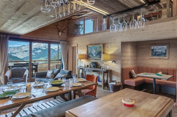 Salle à manger, grande baie vitrée, vue panoramique sur les montagnes et le village