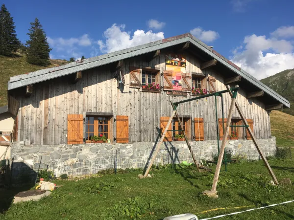 Façade du chalet avec balançoire pour les enfants