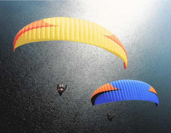 parapentes jaune et bleu au-dessus du lac d'Annecy